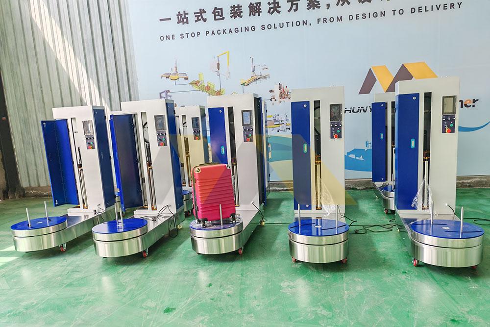 Rail station luggage wrapping machine with heavy duty rollers