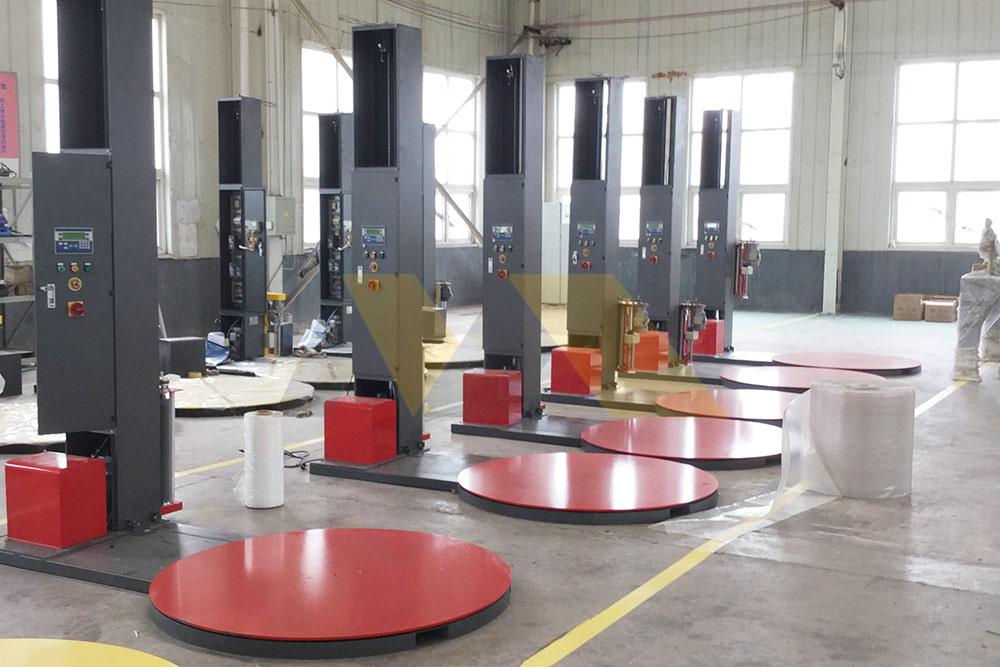 Worker operating semi-automatic pallet wrapping machine controls