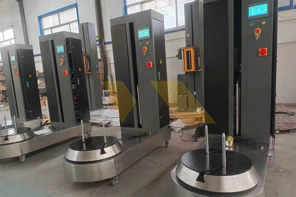 Industrial wrapping machine processing suitcases