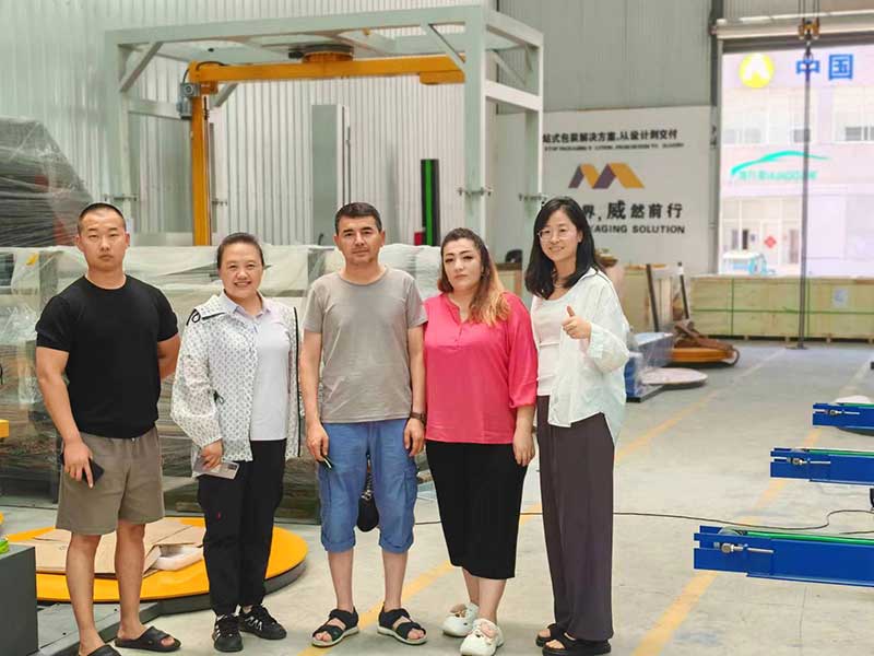 Automatic turntable stretch wrapping machine securing pallet loads with pre-stretched film.